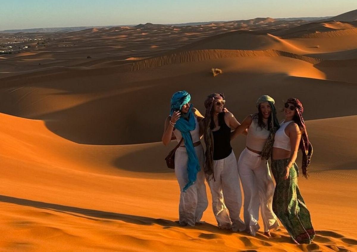 Merzouga camel trekking through golden sand dunes under a starlit Sahara sky with Go Morocco Vacation